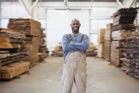 Man standing in lumber warehouse smiling