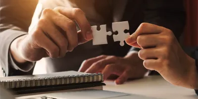 A person putting together two puzzle pieces