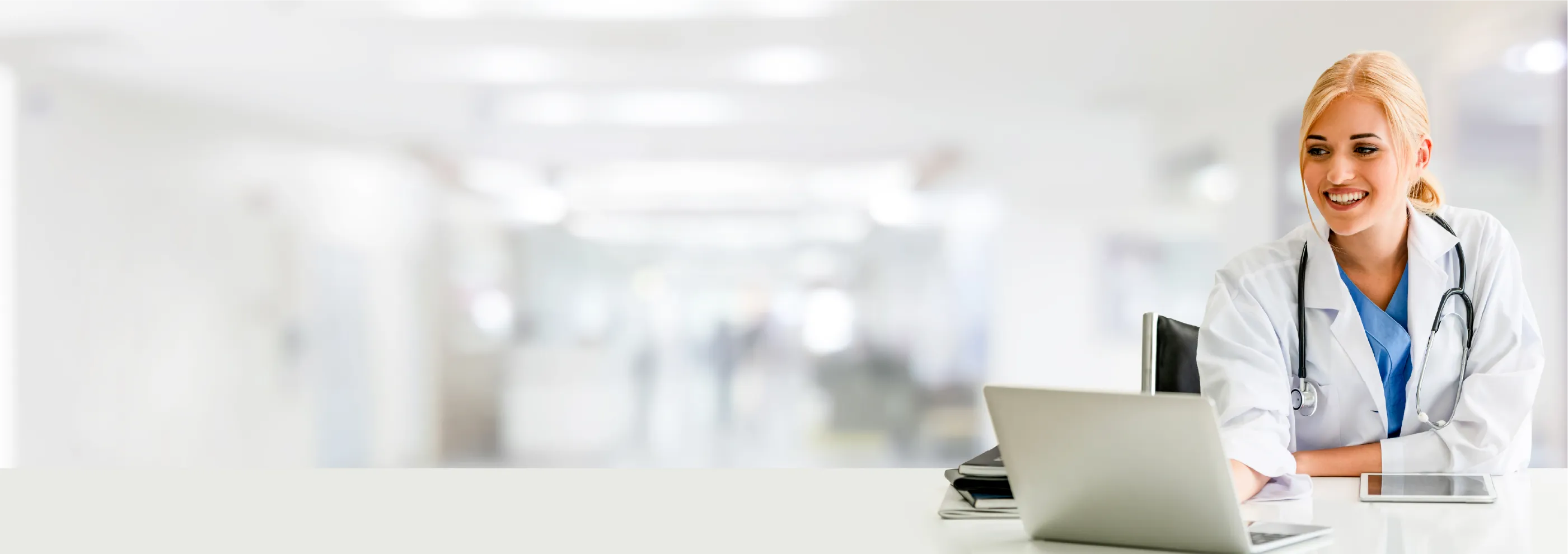 A woman doctor smiling and looking at her computer